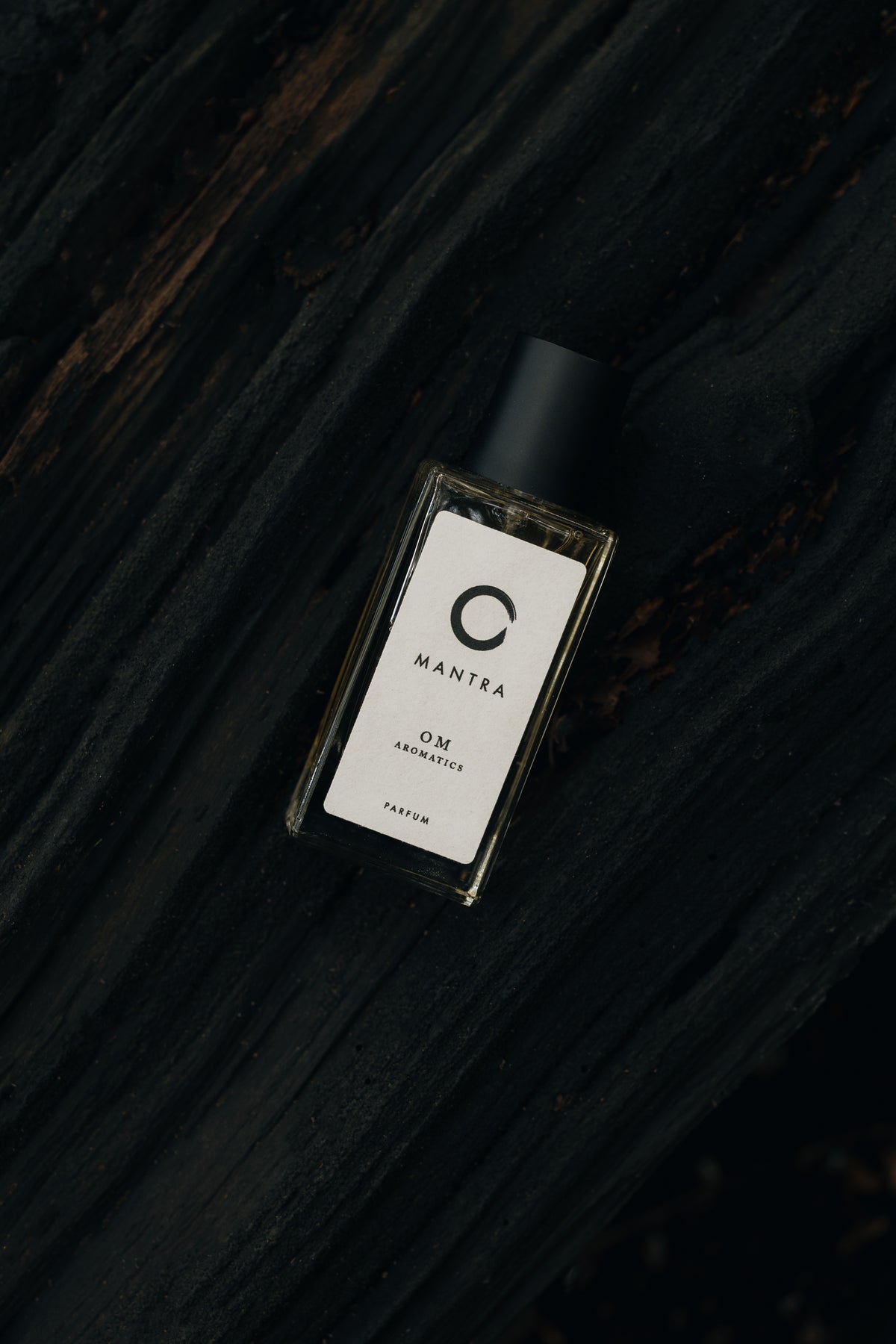 Perfume bottle with a label on a dark wooden surface
