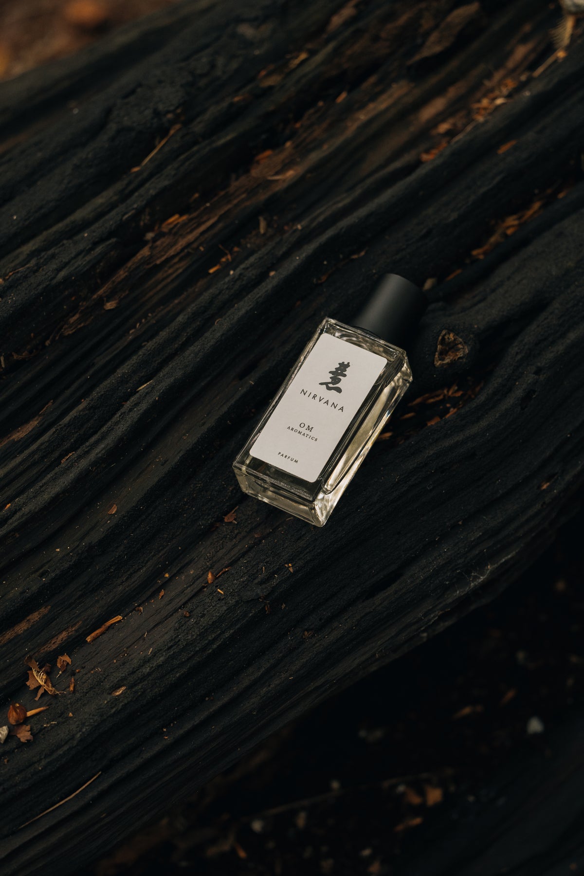 Small bottle of perfume on a dark wooden surface