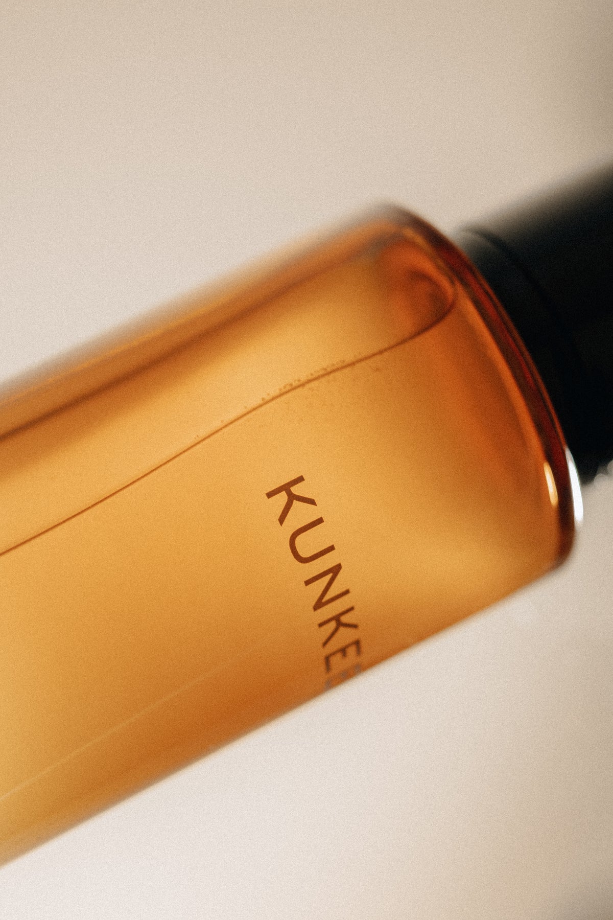 Orange bottle with 'KUNKE' branding on a beige background