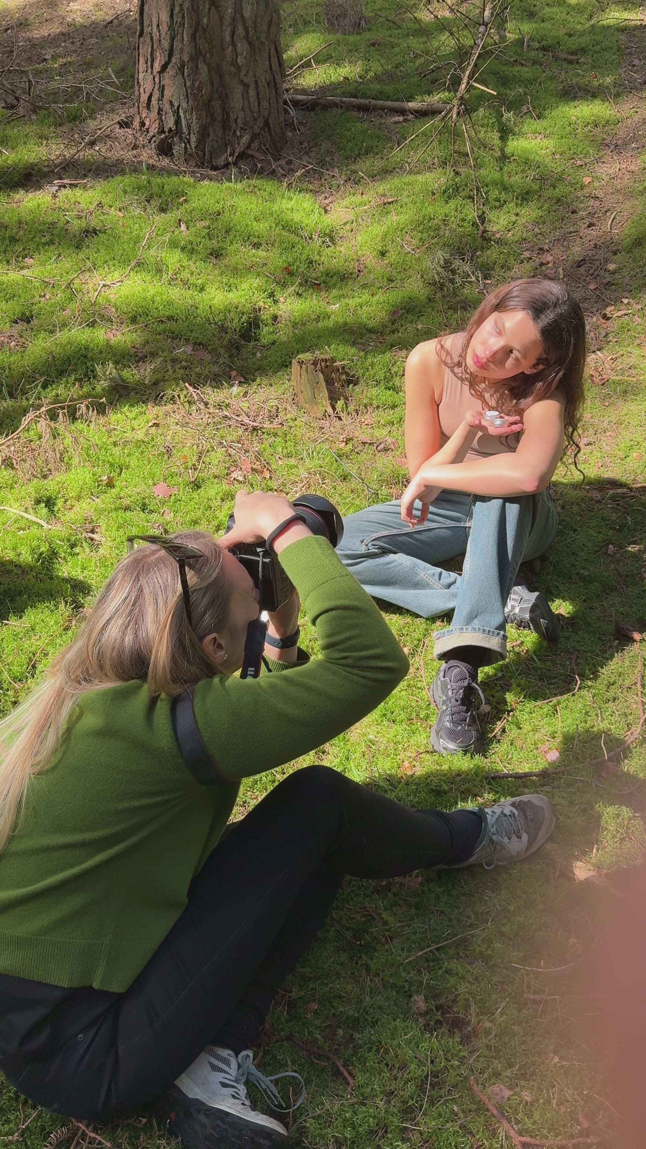 video of two women doing a photoshoot out in the forrest for a beauty brand